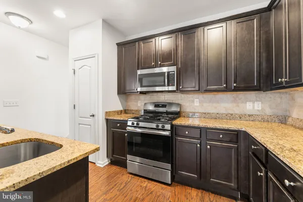 a kitchen with granite countertop a stove and a sink