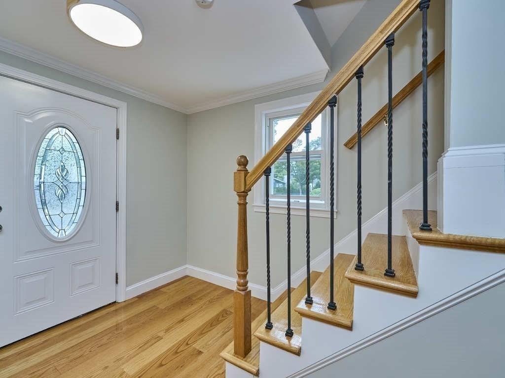 33 Theodore Road Newton, MA 02459 - Photo 17 of 42 a view of a hallway with wooden floor and a dining space with a large window