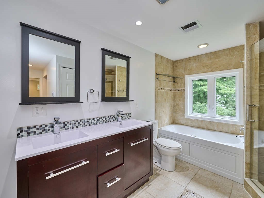 33 Theodore Road Newton, MA 02459 - Photo 18 of 42 a bathroom with a double vanity sink toilet mirror and bathtub