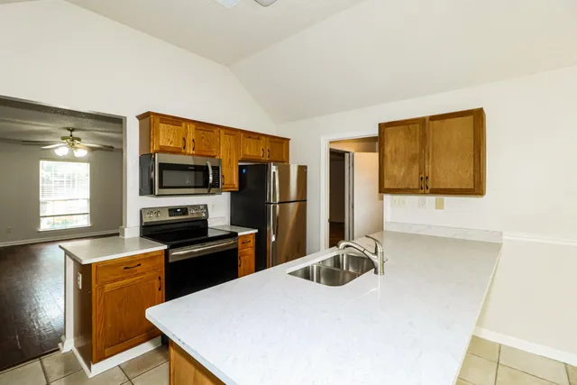 a kitchen with stainless steel appliances a stove refrigerator sink and microwave