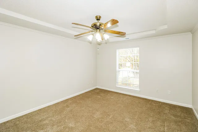 an empty room with windows and fan