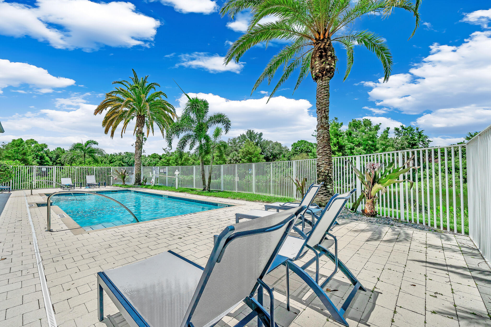 4821 Pointe Midtown Road Palm Beach Gardens, FL 33418 - Photo 57 of 62 a view of a swimming pool with a patio and a garden