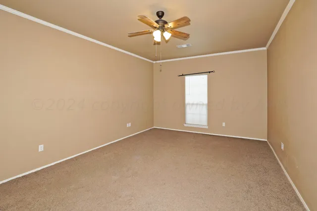 an empty room with a window and a ceiling fan