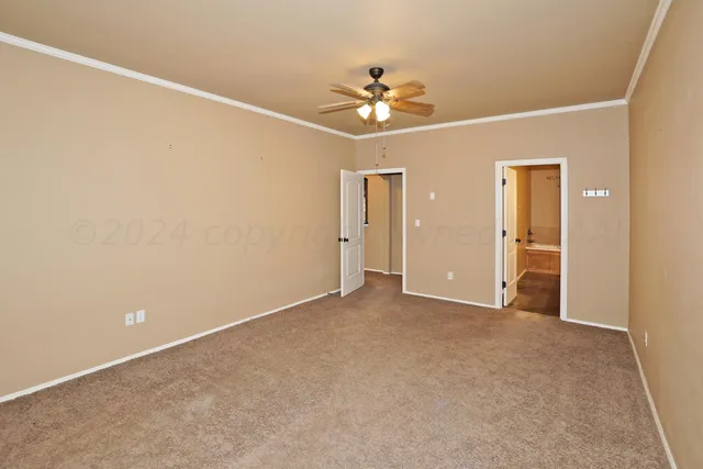 a view of an empty room with a chandelier fan