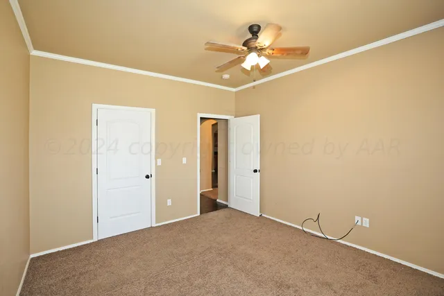 a view of a room with a ceiling fan and a window