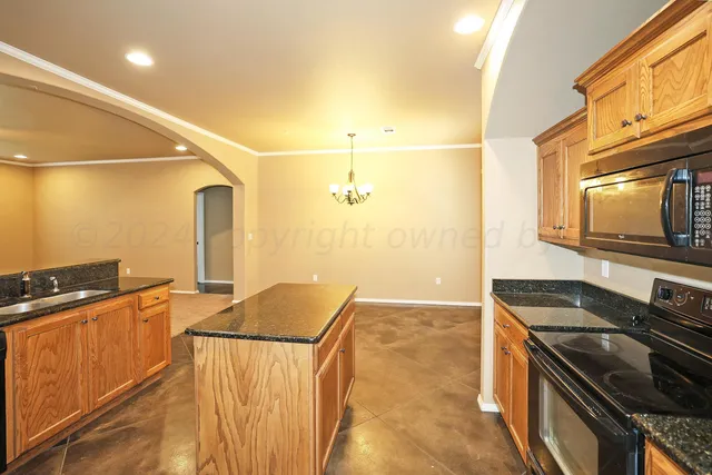 a kitchen with granite countertop a stove and a microwave