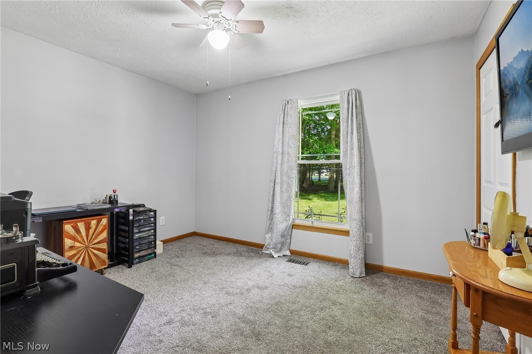 3213 Bates Road Madison, OH 44057 - Photo 23 of 45 Carpeted room with a ceiling fan light fixture, light gray wall paint, and a double-hung window featuring a wooden sill and frame