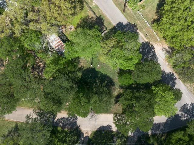 an aerial view of residential house with outdoor space and trees all around