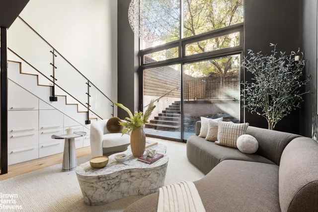 a view of a yard with wooden fence and large trees
