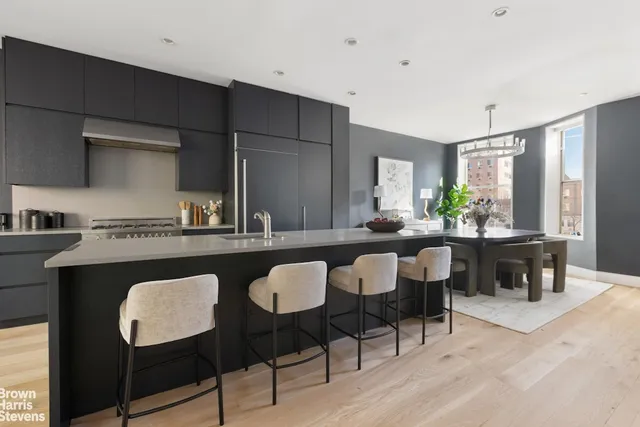 a dining room with furniture a large window and wooden floor