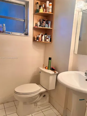a white toilet sitting next to a bathroom sink and vanity