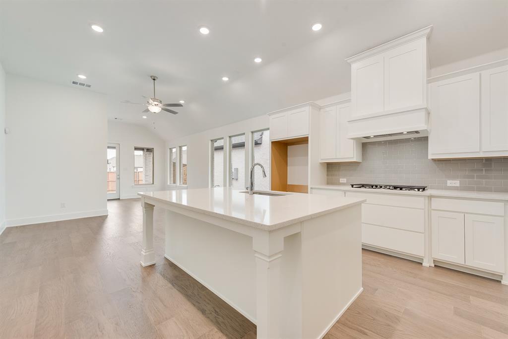 528 Embargo Drive Fate, TX 75189 - Photo 12 of 36 a large kitchen with stainless steel appliances granite countertop a lot of counter space and wooden floors
