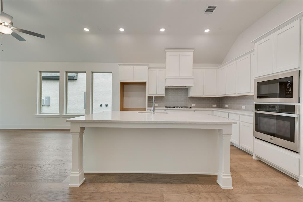 528 Embargo Drive Fate, TX 75189 - Photo 14 of 36 a kitchen with stainless steel appliances granite countertop a stove a sink and a microwave