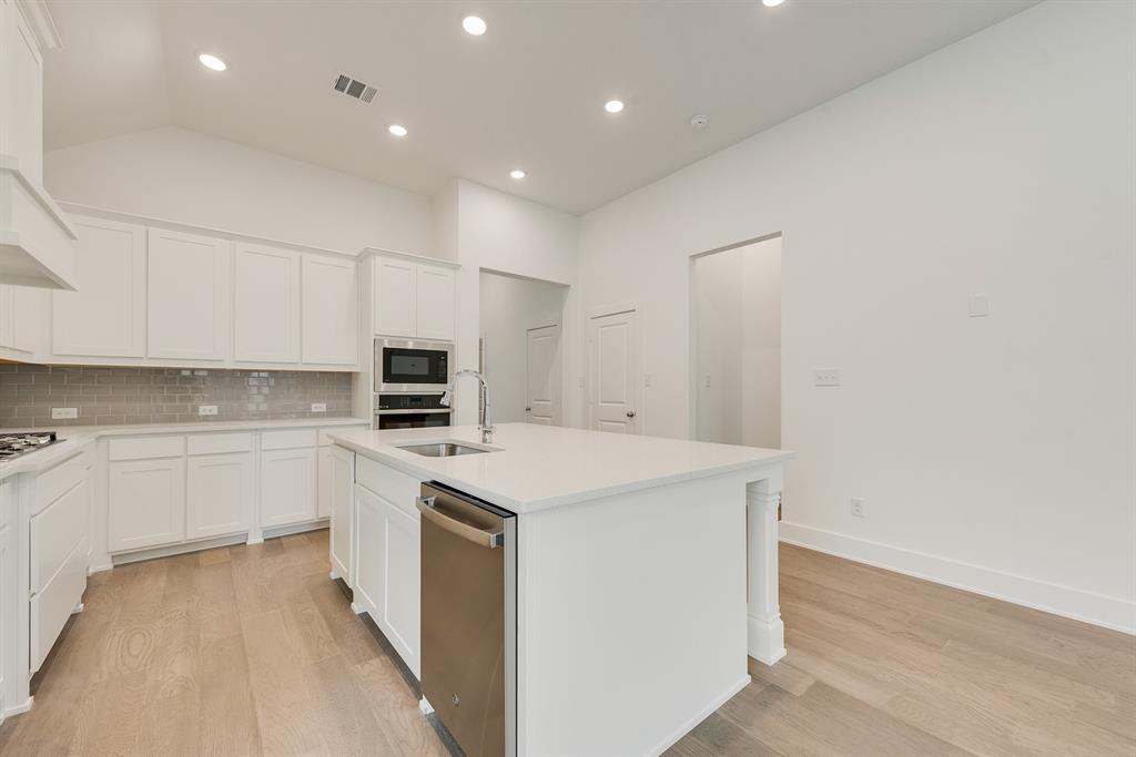 528 Embargo Drive Fate, TX 75189 - Photo 15 of 36 a kitchen with a sink a microwave and cabinets