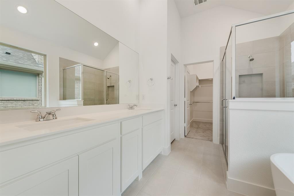 528 Embargo Drive Fate, TX 75189 - Photo 26 of 36 a spacious bathroom with a shower sink and mirror