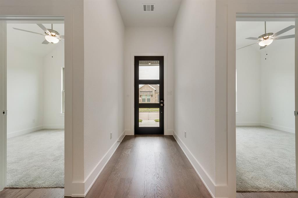528 Embargo Drive Fate, TX 75189 - Photo 5 of 36 a view of a hallway with wooden floor and a bathroom