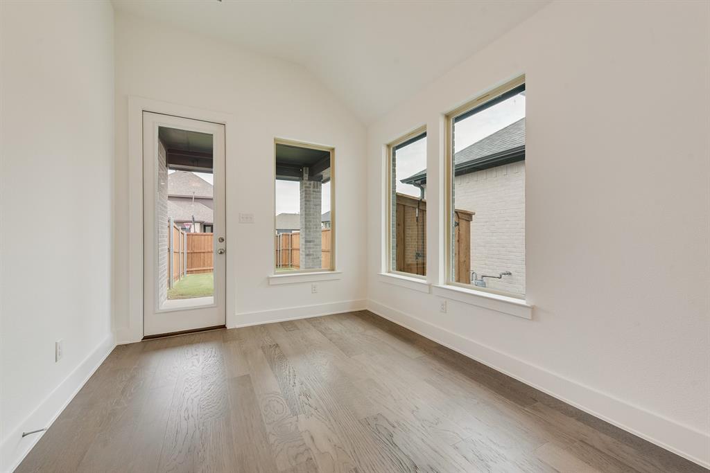 528 Embargo Drive Fate, TX 75189 - Photo 9 of 36 an empty room with wooden floor and windows