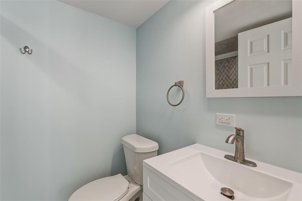 5055 North Beach Road, Unit 108 Englewood, FL 34223 - Photo 21 of 36 a bathroom with a sink mirror vanity and toilet
