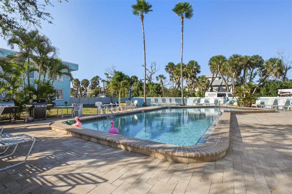 5055 North Beach Road, Unit 108 Englewood, FL 34223 - Photo 29 of 36 a view of a swimming pool with a lawn chairs