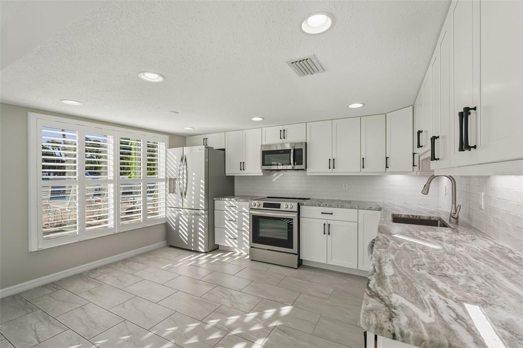 5055 North Beach Road, Unit 108 Englewood, FL 34223 - Photo 7 of 36 a large kitchen with a large window and a refrigerator