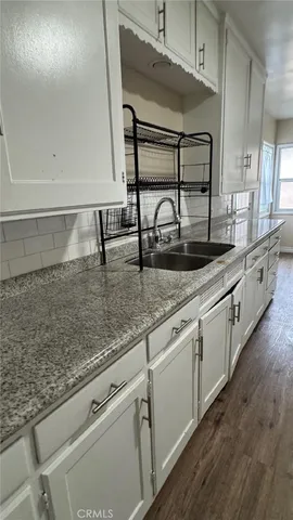 a kitchen with stainless steel appliances granite countertop a sink and a white cabinets