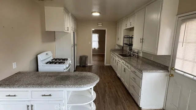 a kitchen with sink stove and refrigerator