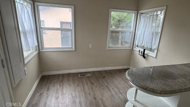 a view of a room that has a window and wooden floor