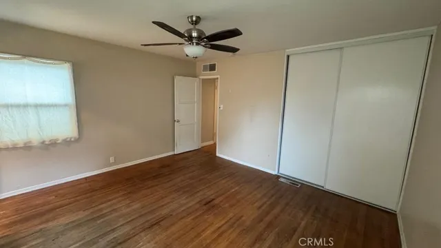 a view of a big room with wooden floor and a ceiling fan