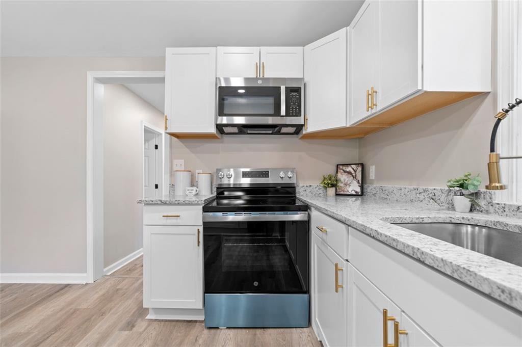 118 Perry Street Monroe, GA 30655 - Photo 14 of 30 a kitchen with granite countertop a stove and a sink
