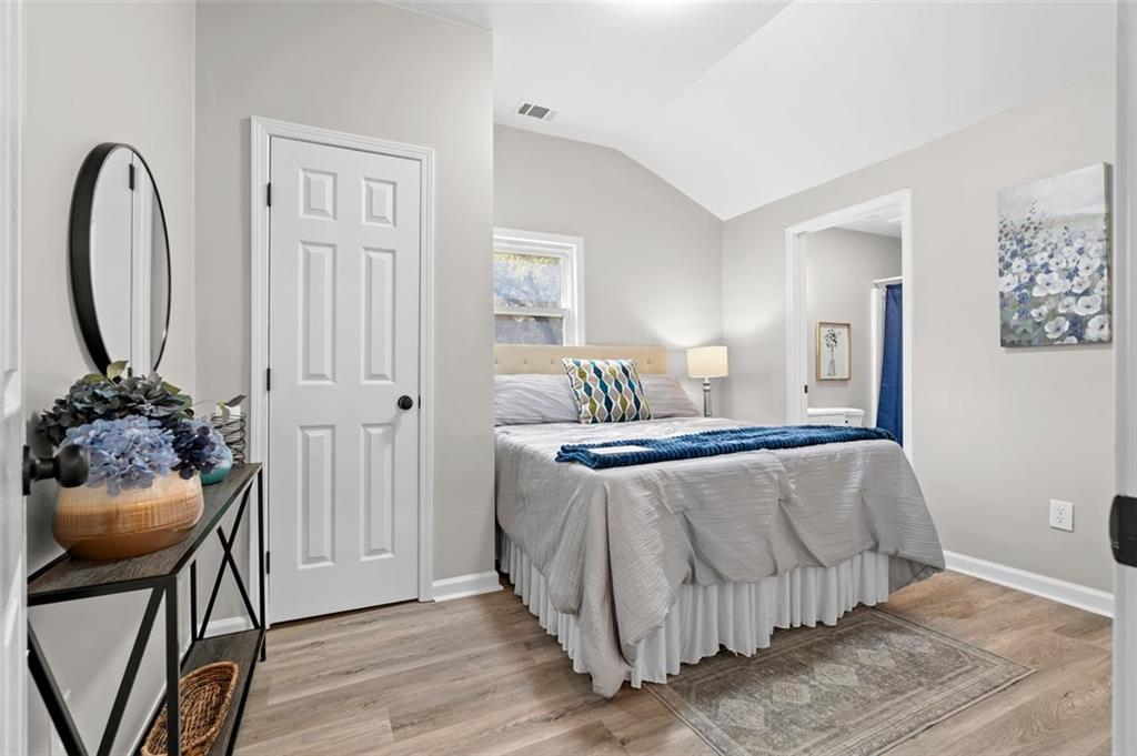 118 Perry Street Monroe, GA 30655 - Photo 17 of 30 a bedroom with a bed and a potted plant on dresser