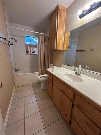 a bathroom with a toilet a sink a mirror and a window