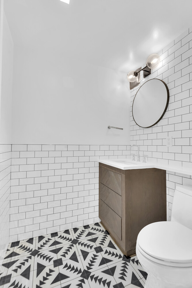 25 Sutton Place South, Unit 14A Manhattan, NY 10022 - Photo 10 of 17 a bathroom with a toilet sink and mirror