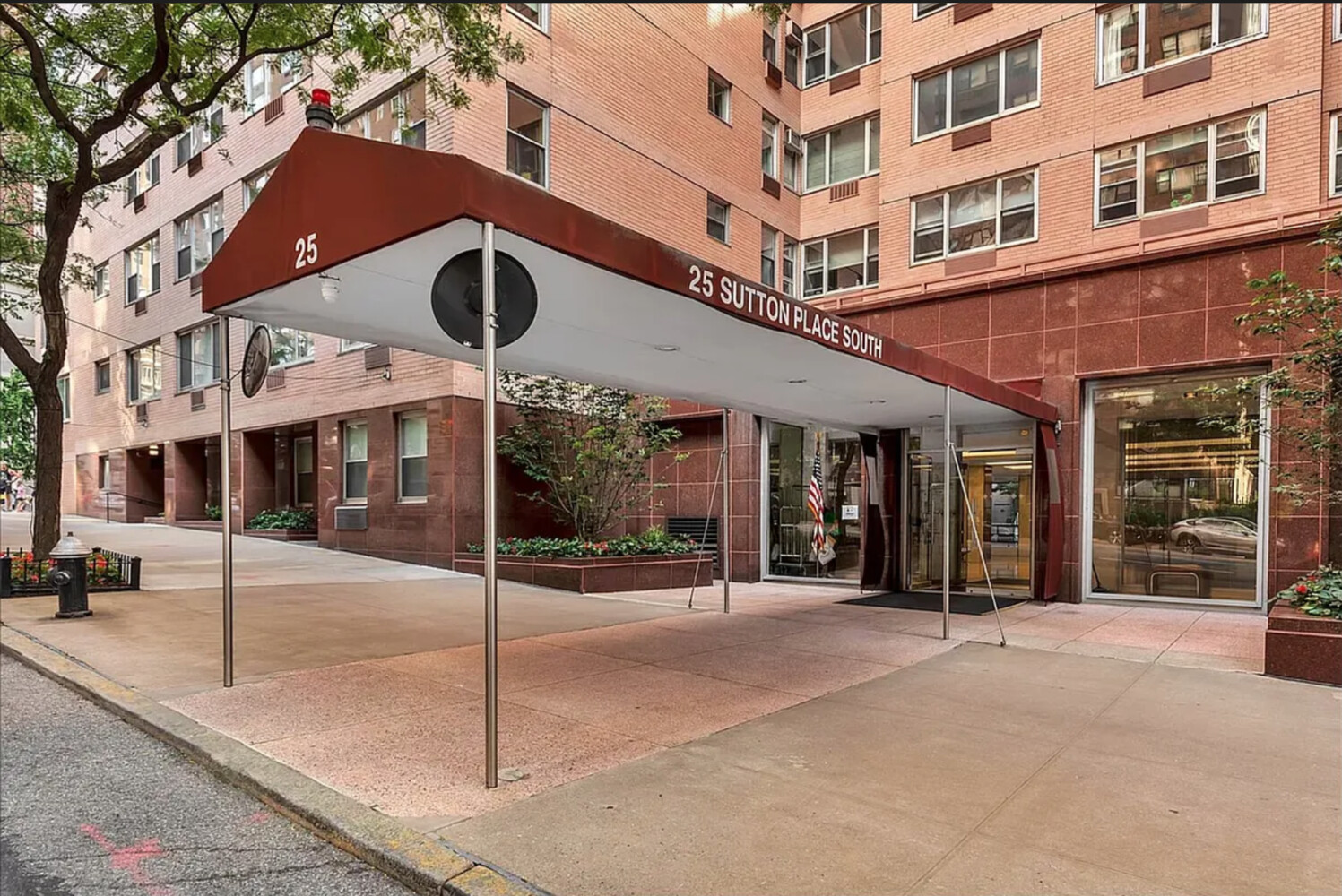 25 Sutton Place South, Unit 14A Manhattan, NY 10022 - Photo 16 of 17 a view of a building with a tree in front of it