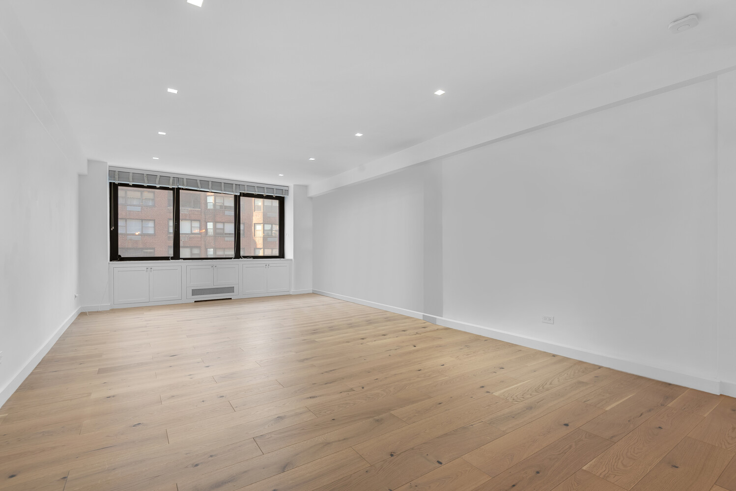 25 Sutton Place South, Unit 14A Manhattan, NY 10022 - Photo 2 of 17 an empty room with wooden floor and windows