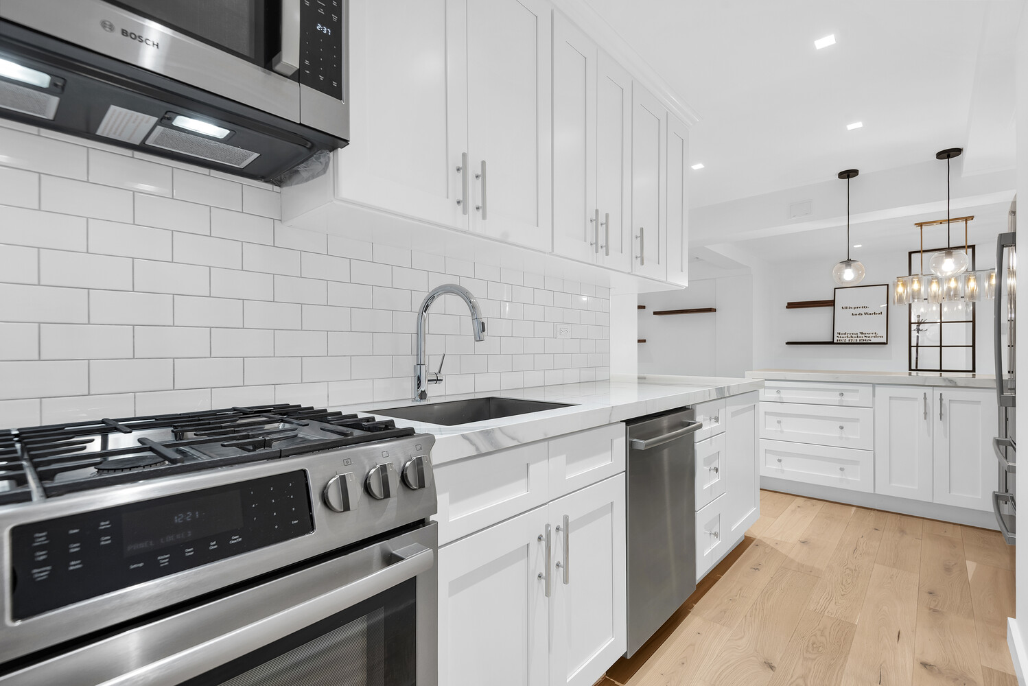 25 Sutton Place South, Unit 14A Manhattan, NY 10022 - Photo 5 of 17 a kitchen with stainless steel appliances granite countertop a stove and white cabinets