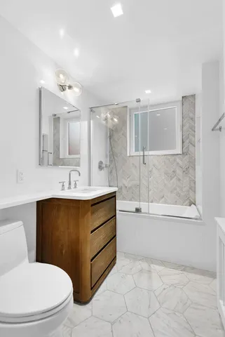 a bathroom with a sink toilet mirror and bathtub