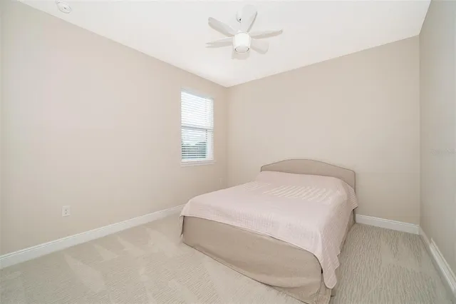 a room with a bed and a ceiling fan