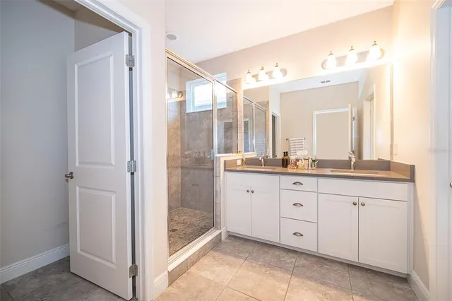 a spacious bathroom with a shower sink and mirror