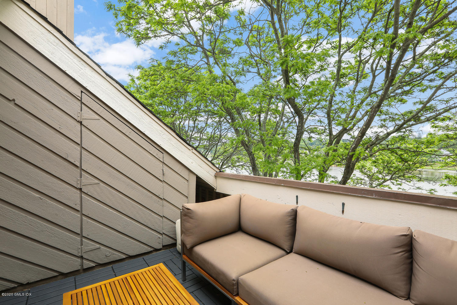 11 River Road, Unit 112 Cos Cob, CT 06807 - Photo 25 of 27 a view of a balcony with couches and wooden fence