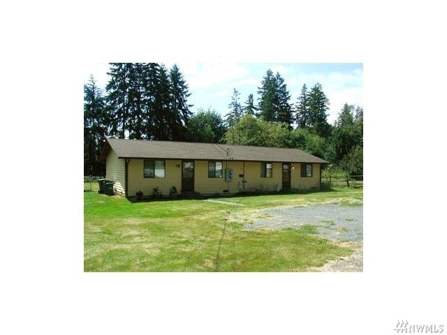 a view of a house with yard and sitting area