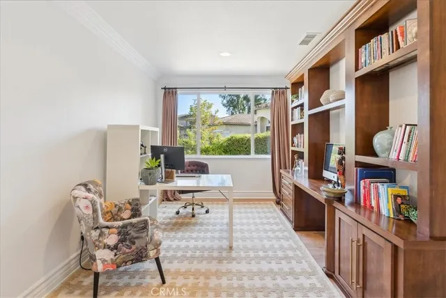 a work room with furniture a bookshelf and a window