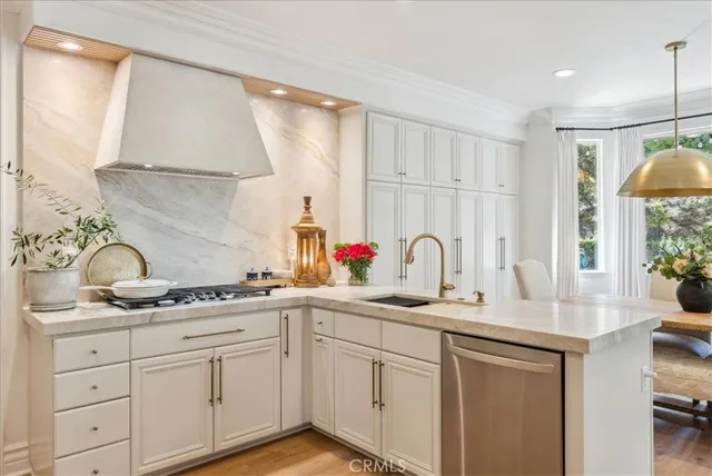 a kitchen with white cabinets and sink
