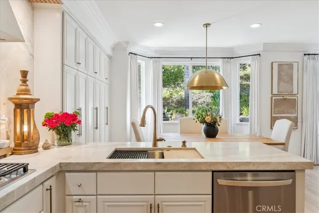 a kitchen with kitchen island granite countertop a sink cabinets and a large window