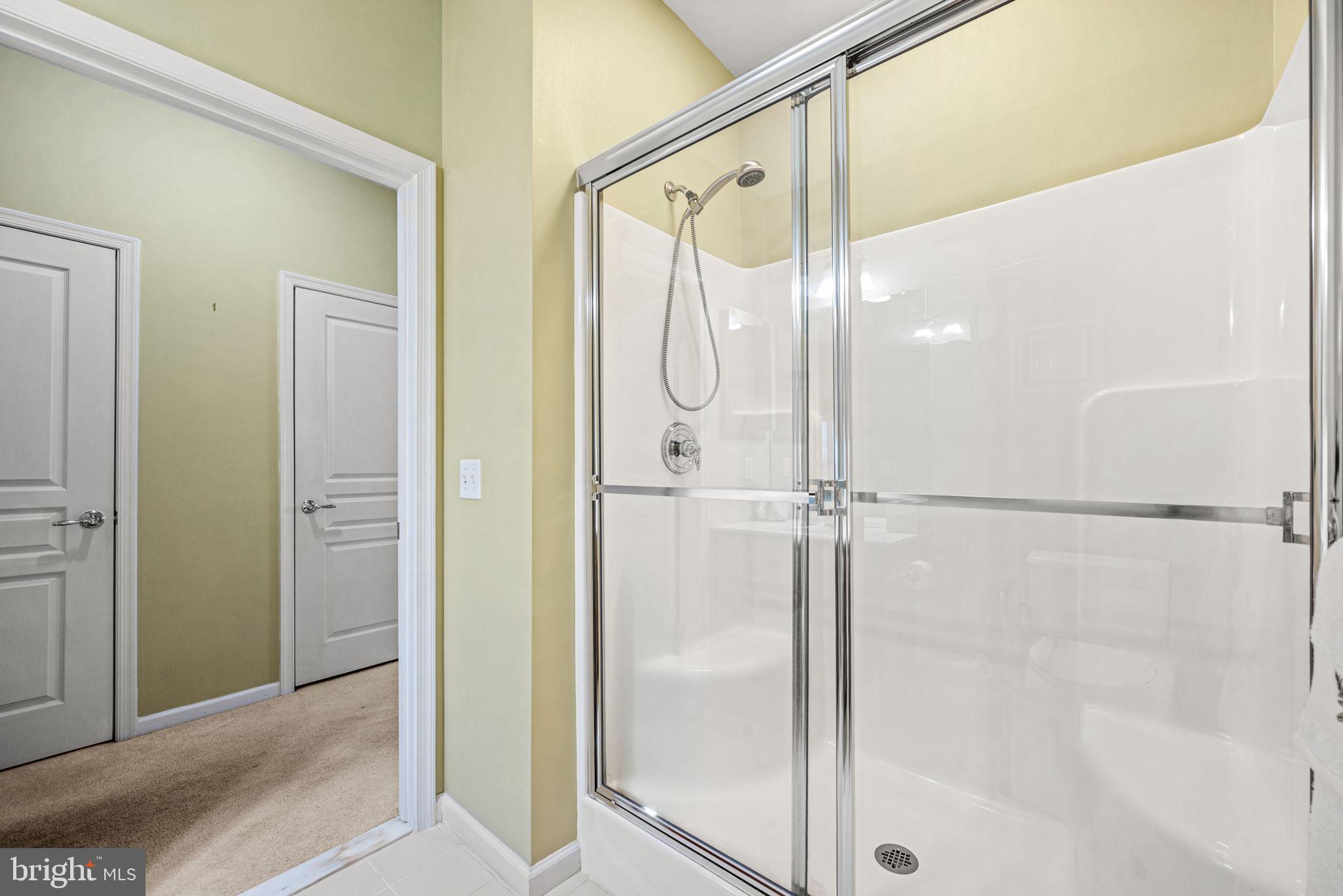 113 Creekside Drive, Unit 3 Brookhaven, PA 19015 - Photo 17 of 26 a bathroom with a glass shower door and a mirror