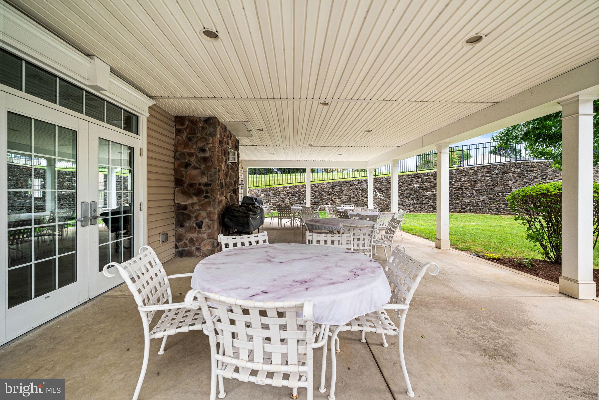 113 Creekside Drive, Unit 3 Brookhaven, PA 19015 - Photo 25 of 26 a view of a patio with a dining table and chairs