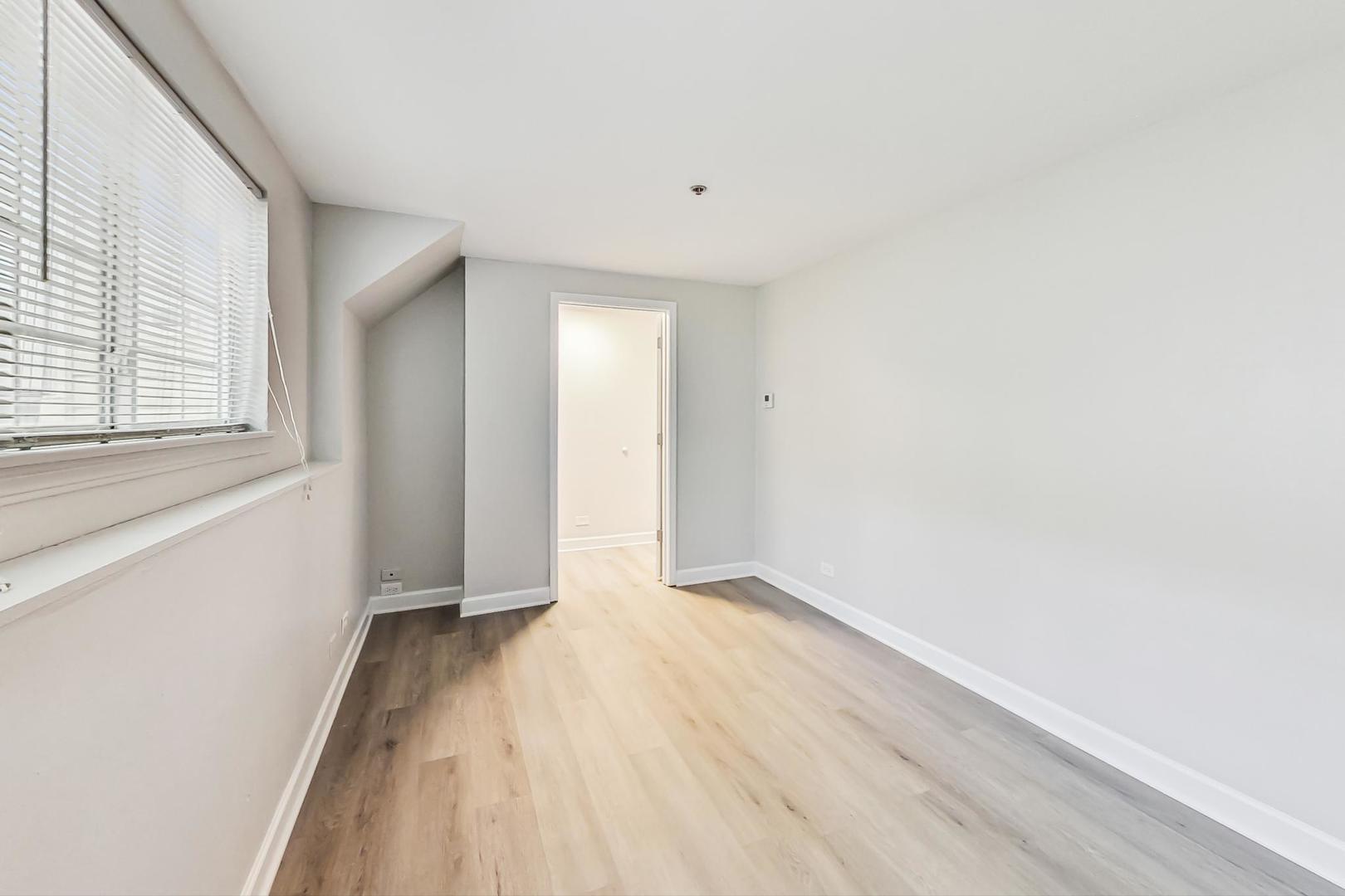 313 Rosebud Court, Unit 313 Bolingbrook, IL 60440 - Photo 14 of 31 a view of an empty room with wooden floor and a window