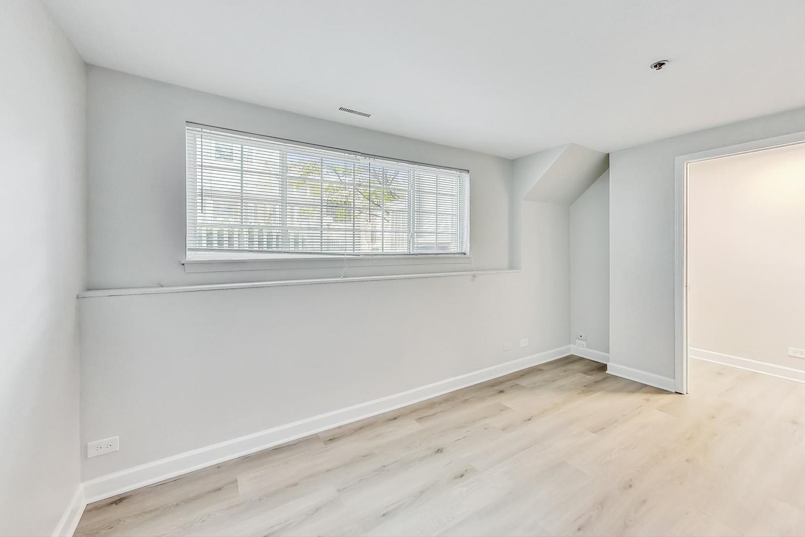 313 Rosebud Court, Unit 313 Bolingbrook, IL 60440 - Photo 26 of 31 a view of an empty room with wooden floor and a window