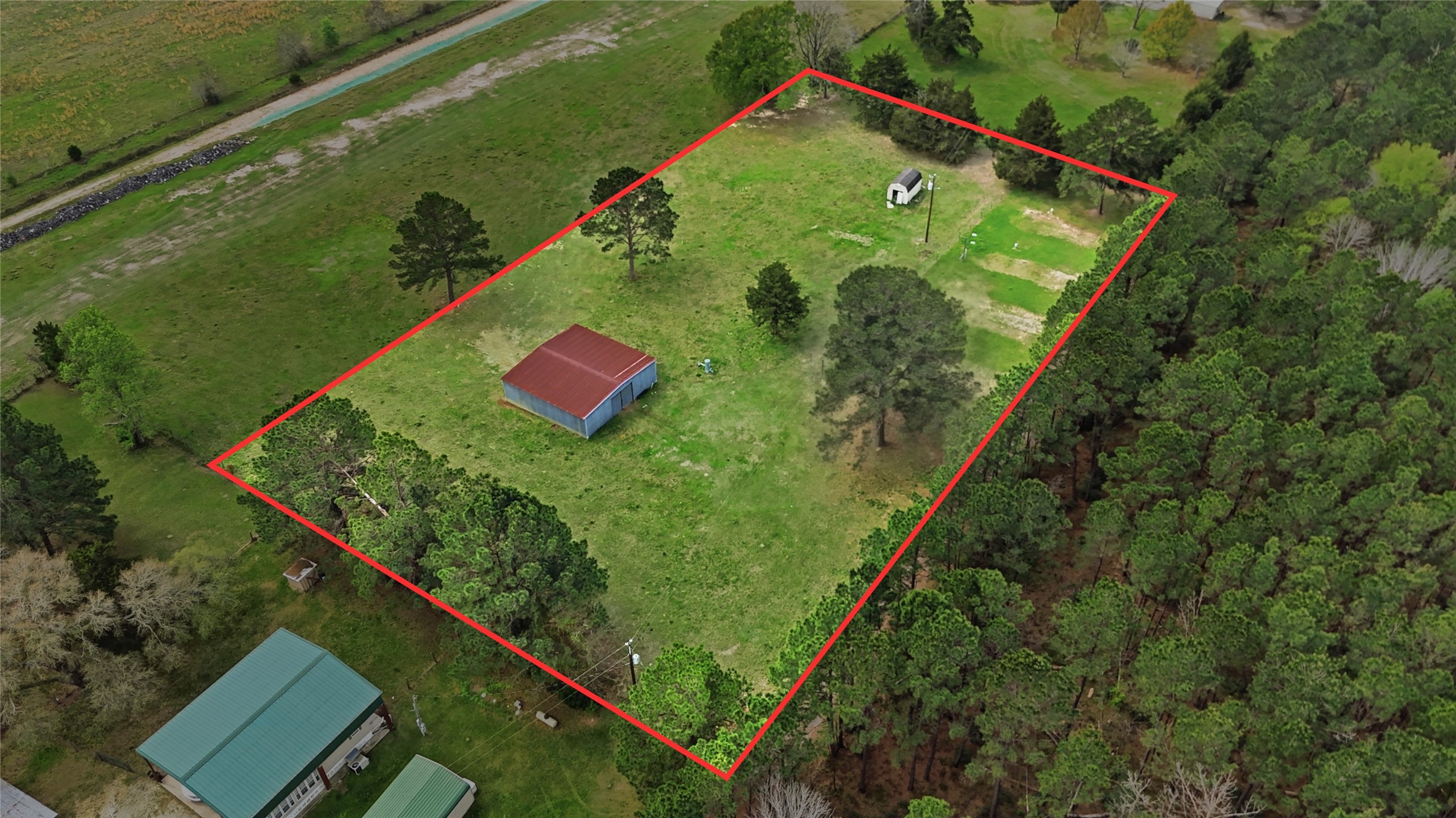 872 Four Notch Road Huntsville, TX 77340 - Photo 20 of 42 Expansive, tree-lined lot featuring a spacious barn, offering ample potential for customization and development.