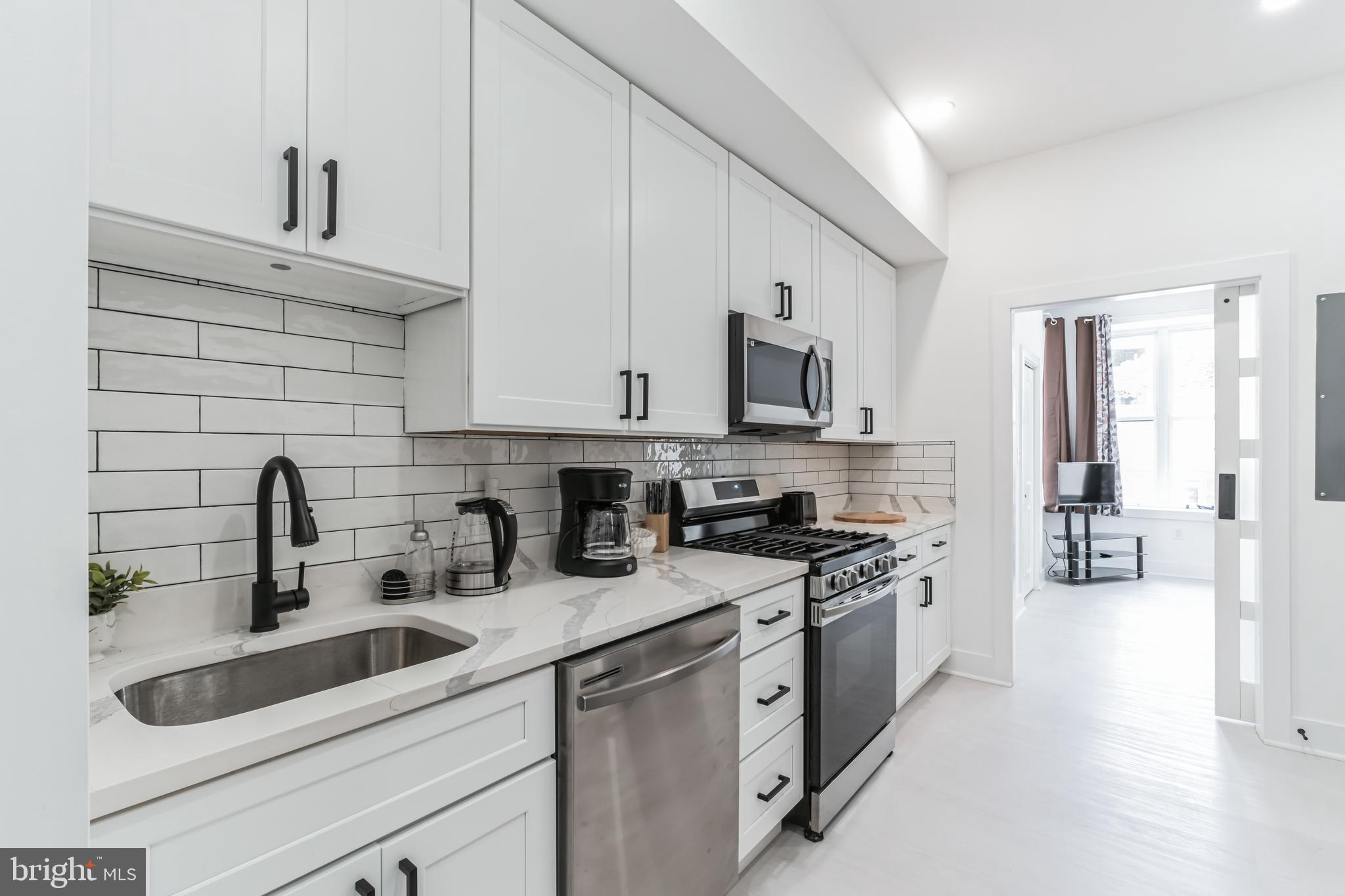 33 Florida Avenue Northeast, Unit 3 Washington, DC 20002 - Photo 2 of 15 a kitchen with stainless steel appliances granite countertop white cabinets a sink a stove a refrigerator and white cabinets