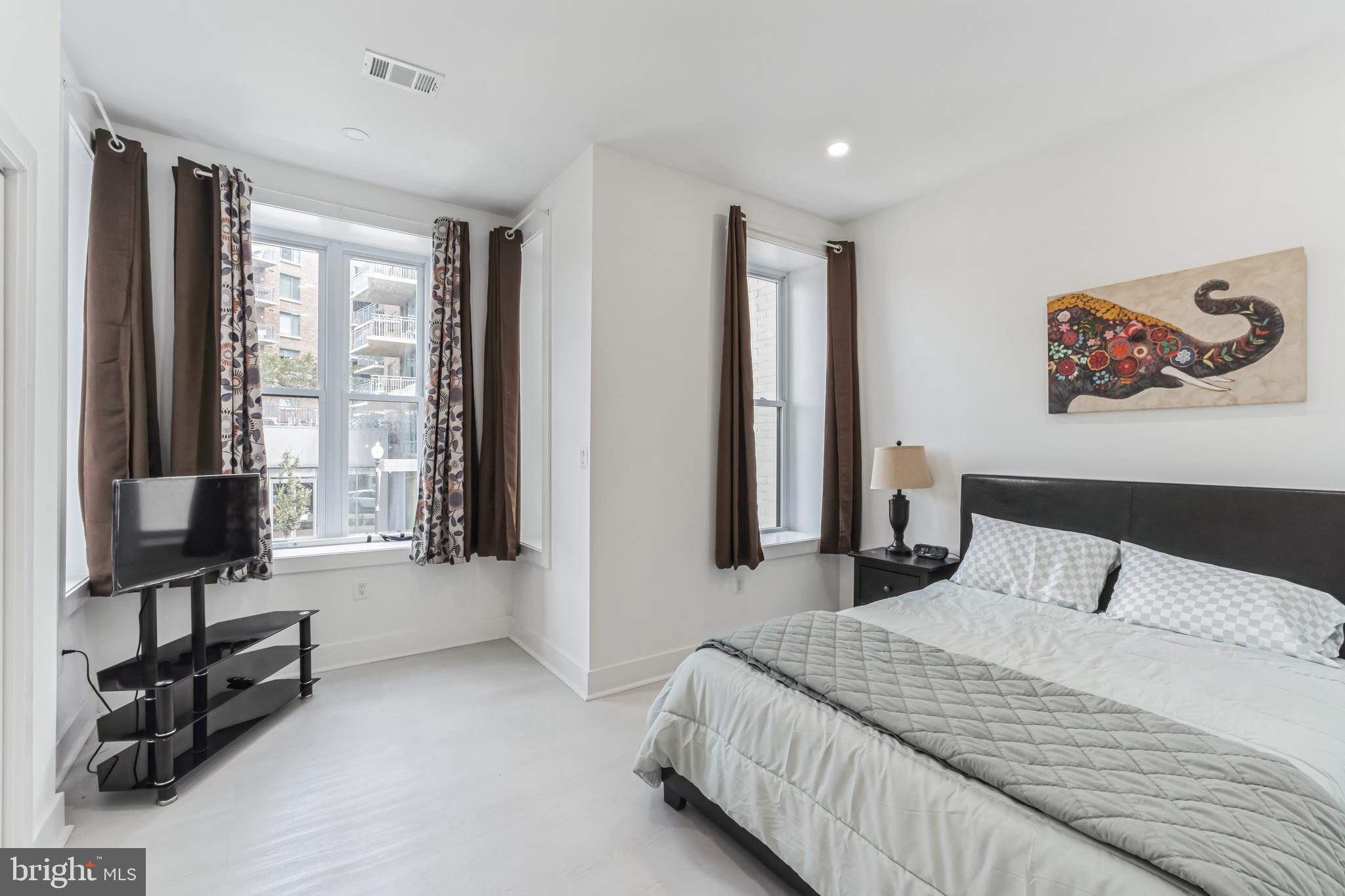 33 Florida Avenue Northeast, Unit 3 Washington, DC 20002 - Photo 6 of 15 a bedroom with a bed and a flat tv screen on the dresser